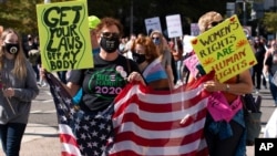 Demonstrators march on Pennsylvania Avenue during the Women's March in Washington, Oct. 17, 2020. 