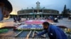 Un hombre enciende velas en nombre de los fieles en la Basílica de Guadalupe que está temporalmente cerrada para evitar multitudes en el tradicional día de celebración de la Virgen de Guadalupe, el 12 de diciembre, mientras sigue el brote de coronavirus.