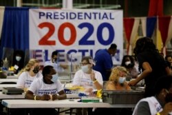Election workers open ballots at the Palm Beach County Elections Office during the 2020 U.S. presidential election in West Palm Beach, Florida, Nov. 3, 2020.