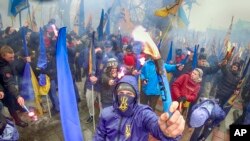 Members of nationalist groups light flares during a rally to mark the third anniversary of the Maidan protests at the Ukrainian Parliament, in Kyiv, Ukraine, Feb. 22, 2017.
