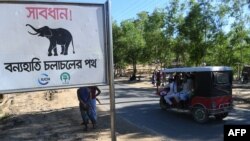 FILE - A sign reading "Warning! - Route for Wild Elephants" is pictured near Balukhali camp for Rohingya refugees, in Cox's Bazar, Bangladesh, Oct. 14, 2017.