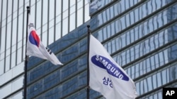 FILE - A flag of Samsung, right, and South Korean national flag are seen outside the Samsung Electronics' Seocho building in Seoul, South Korea, July 5, 2024.