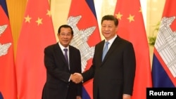 រូបឯកសារ៖ លោកនាយករដ្ឋមន្ត្រី ហ៊ុន សែន ចាប់ដៃ​ជាមួយ​លោក​ប្រធានាធិបតីចិន ស៊ី ជីនពីង មុន​កិច្ចប្រជុំនៅវិមានរដ្ឋាភិបាលចិនប្រចាំទីក្រុង​ប៉េកាំង ប្រទេស​ចិន ថ្ងៃទី២៩ ខែមេសា ឆ្នាំ២០១៩។ 