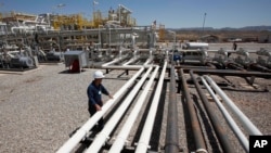 FILE - An employee works at an oil field in the Kurdish region in northern Iraq.