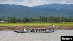 People walk past a screen showing the news report that President Donald Trump has tested positive for the coronavirus, in Tokyo. 