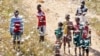Local youth and children stand in a swarm of locust flying over in Soatana village, southern Madagascar on May 29, 2011.