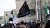 FILE - Protesters carry Al-Qaida flags during an anti-government demonstration after Friday prayers in the town of Marat Numan in Idlib province, Syria, on March 11, 2016.
