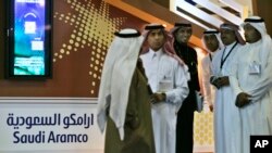 FILE - Employees of the Saudi Aramco oil company prepare for the first day of the Arab Oil and Gas exhibition in Dubai, United Arab Emirates. 