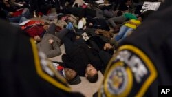 Para demonstran dalam aksi pura-pura mati di Stasiun Grand Central sebagai bagian dari protes melawan keputusan dewan juri New York untuk tidak mendakwa polisi yang membunuh pria berkulit hitam, Eric Garner (6/12). (AP/John Minchillo) 