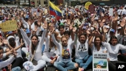 Lilian Tintori, front fourth from right, wife of jailed opposition leader Leopoldo Lopez, leads a sit-in blocking the Franciso Fajardo highway after a women march against repression was blocked from reaching the Interior Ministry in Caracas, Venezuela, Saturday, May 6, 2017.