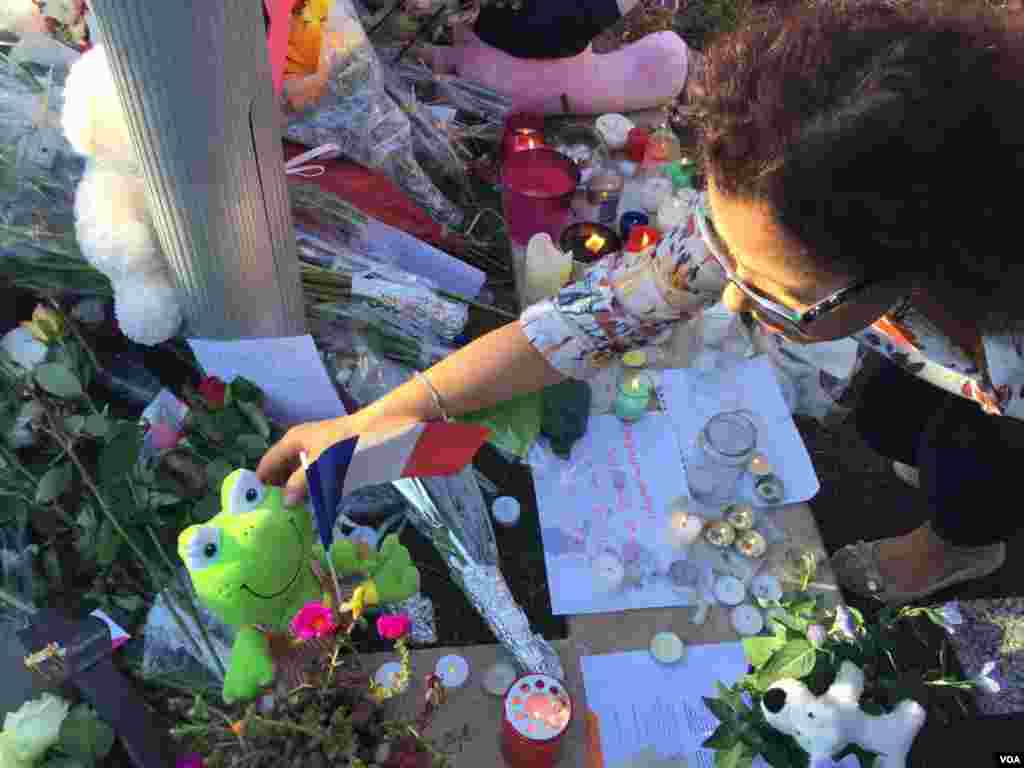 Woman lays down flowers in honor of victims of Bastille Day truck attack in Nice, France, July 15, 2016. (Photo: VOA Persian Service)