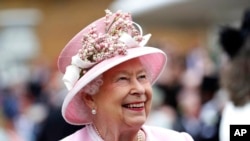 FILE - Britain's Queen Elizabeth arrives for a Royal Garden Party at Buckingham Palace in London, May 29, 2019.