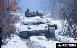 Service members of the Ukrainian Armed Forces ride atop of a tank during military drills in the Donetsk region, Ukraine, in this handout picture released Feb. 4, 2022. (Press service of the Joint Forces Operation/Handout via Reuters)