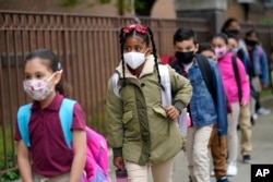 FILE - Students line up to enter Christa McAuliffe School in Jersey City, New Jersey, April 29, 2021.