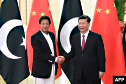 Presiden China Xi Jinping (kanan) berjabat tangan dengan Perdana Menteri Pakistan Imran Khan (kiri) sebelum pertemuan mereka di Aula Besar Rakyat di Beijing pada 28 April 2019. (Foto: AFP)