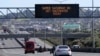 FILE - A sign on an Auckland motorway urges people to get vaccinated at a COVID-19 vaccination clinic during a single-day vaccination drive, in Auckland, New Zealand, Oct. 16, 2021. 