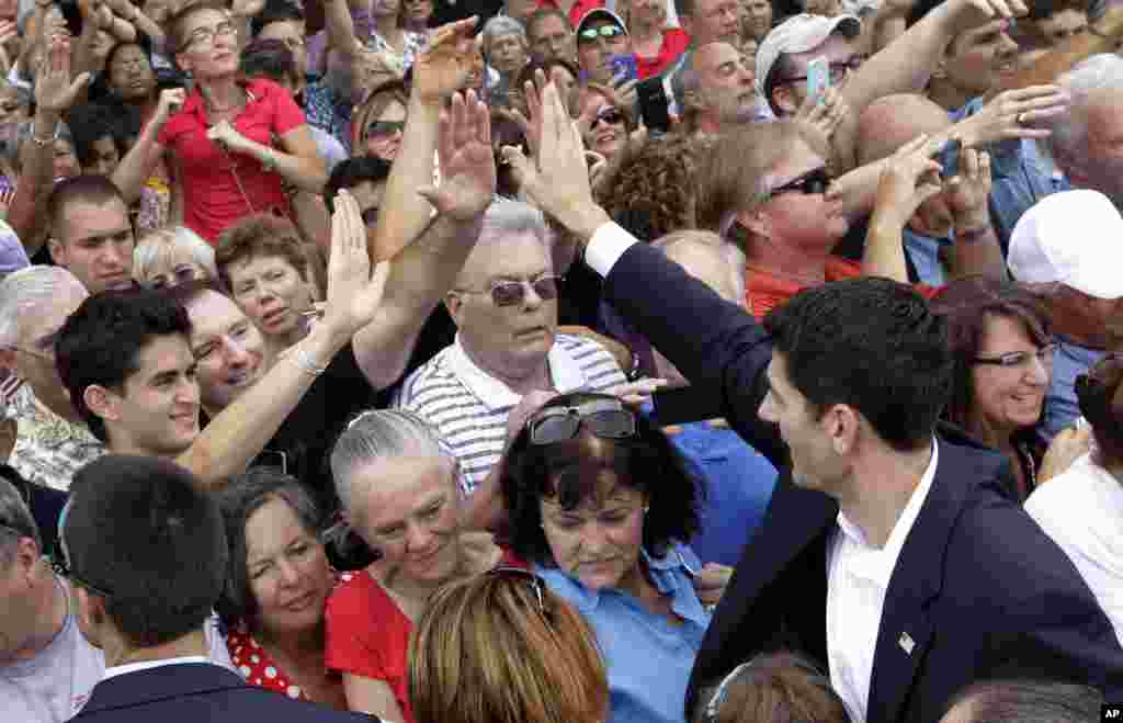 Rep. Paul Ryan high-fives people in the crowd after speaking at a campaign event, Aug. 11, 2012, in Norfolk, Va. 