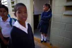 A girl waits at the entrance of her classroom for her teacher's arrival, on her first day of class at the Jerman Ubaldo Lira public school in Caracas, Venezuela, Oct. 2, 2019.