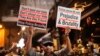 A man holds signs decrying police brutality in Hong Kong, Oct. 31, 2019. 