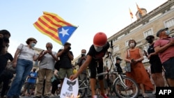 Anti-monarchy demonstrators burn pictures of the Spanish king during a protest against the visit of King Felipe VI of Spain to Catalonia, in Barcelona, June 15, 2021.