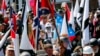 FILE - White nationalist demonstrators walk into the entrance of Lee Park surrounded by counterdemonstrators in Charlottesville, Va., Aug. 12, 2017. 
