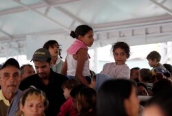 Venezuelans wait at an immigration processing office on the Rumichaca bridge, before crossing the border from Colombia to Ecuador, June 13, 2019.