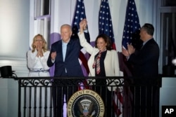 El presidente Joe Biden y la vicepresidenta Kamala Harris se dan la mano al llegar a ver los fuegos artificiales del 4 de julio desde el balcón de la Casa Blanca en Washington, el jueves 4 de julio de 2024. (Foto AP/Susan Walsh)