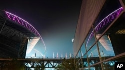 Smoke from wildfires is seen in the air as lights from T-Mobile Park, left, are reflected in a window of CenturyLink Field, right, following an MLS soccer match between the Seattle Sounders and the San Jose Earthquakes, Sept. 10, 2020, in Seattle.