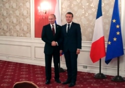 French President Emmanuel Macron, right, and Russian President Vladimir Putin pose for a photo during a meeting on the sidelines of the G-20 summit in Osaka, Japan, June 28, 2019.
