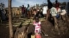 FILE - An internally displaced Congolese girl goes to fill a water bottle inside a IDP camp, in Bunia, Ituri province, DRC, March 02, 2018, as violence continues between the region's Hema and Lendu communities.