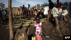 FILE - An internally displaced Congolese girl goes to fill a water bottle inside a IDP camp, in Bunia, Ituri province, DRC, March 02, 2018, as violence continues between the region's Hema and Lendu communities.