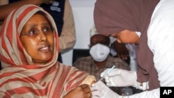FILE - Somalia's Minister of Health Fawziya Abikar Nur, receives a shot of AstraZeneca COVID-19 vaccine at a ceremony to mark the start of coronavirus vaccinations in Mogadishu, Somalia, March 16, 2021.