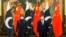 FILE - In this photo released by Xinhua News Agency, Chinese President Xi Jinping, right, and Pakistan Prime Minister Imran Khan pose for a photo before their bilateral meeting at the Great Hall of the People in Beijing, Feb. 6, 2022. 