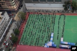 An aerial view of people lining up to get tested for the coronavirus at a makeshift testing site in Hong Kong, Feb. 9, 2022.