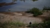 FILE - This Oct. 31, 2019, photo shows a fisherwoman walking on an embankment of the drought-stricken Mekong river in Pak Chom district in the northeastern Thai province of Loei. 