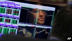 Specialist Frank Masiello is reflected in his screen on the floor of the New York Stock Exchange, Aug. 24, 2015.