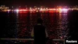 Մարդիկ հետևում են Պոտոմակ գետի ափից շտապ օգնության մեքենաների աշխատանքին, հունվարի 30, Արլինգտոն, Վիրջինիա նահանգ