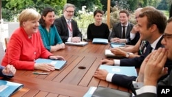 French President Emmanuel Macron, right, meets German Chancellor Angela Merkel at the Elysee Palace in Paris, Aug.28, 2017. 