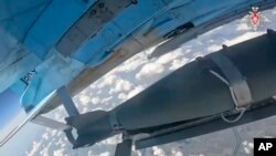 Фото, опубліковане Міністерством оборони Росії, зображує плануючу бомбу у невстановленому місці. Russian Defense Ministry Press Service photo via AP