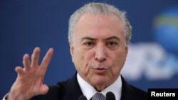 FILE - Brazil's President Michel Temer gestures during the launch of the new financing line of Bank Caixa Economica Federal Brasilia, Nov. 24, 2016. 