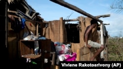 Un jeune homme devant les restes d'une maison à Mananjary, Madagascar, le 9 février 2022.