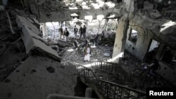 Petugas keamanan dan jurnalis memeriksa stasiun telekomunikasi yang hancur akibat serangan udara yang dilancarkan oleh pasukan Arab Saudi di Sana'a, Yaman, pada 14 Februari 2022. (Foto: Reuters/Khaled Abdullah)