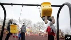 FILE - Afghan refugee mothers and children play in a park on Joint Base McGuire-Dix- Lakehurst in Trenton, N.J., Dec. 2, 2021.