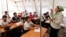 FILE - Children listen to their teacher during a lesson at a local school, based in a tent, in the city of Osh, Kyrgyzstan.