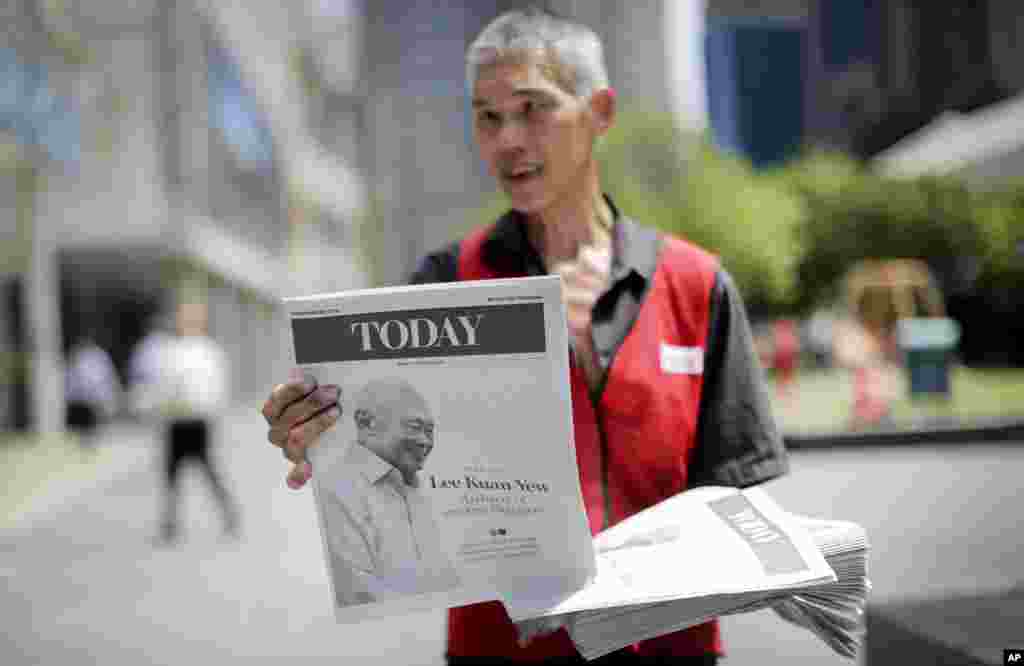 A vendor hands out a special edition of the local newspaper featuring the life of the late Lee Kuan Yew, Singapore, March 23, 2015.