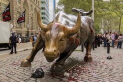 In this freeze frame made from a video, fake blood covers the iconic Charging Bull statue near Wall Street in New York, Oct. 7, 2019.