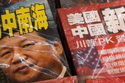 In this July 4, 2019, photo, magazines with front covers featuring Chinese President Xi Jinping with South China Sea and Xi against U.S. President Donald Trump are placed on sale at a roadside bookstand in Hong Kong.