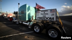 Truckers and their supporters start to gather before a convoy leaves the following morning bound for the nation's capital to protest against COVID-19 vaccine mandates, in Adelanto, California, Feb. 22, 2022.
