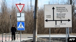 A man walks past a road sign in the town of Avdiivka, Donetsk region, located on the front-line with Russia-backed separatists, Feb. 21, 2022.