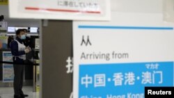 Miembros del personal del aeropuerto de Narita, en Japón, se cubren el rostro con máscaras ante la propagación del coronavirus, originado en China.